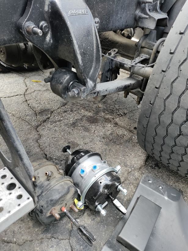 A new air brake chamber next to the axle of a semi